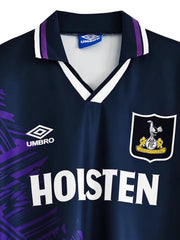 トッテナムのエンブレム刺繍のディテール、紫の幾何学模様のディテール、黒白紫のストライプ襟のデザイン