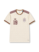 2026年スペイン代表ワールドカップアウェイユニフォーム正面、アイボリーホワイトボディ、同系色総柄、胸元スペイン代表エンブレム、ワインレッド背番号19、ワインレッド肩ストライプ、ゴールド襟トリム