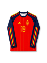 2026年スペイン代表ワールドカップホームロングスリーブユニフォーム正面、レッドボディ、イエローピンストライプ、ネイビースリーブ、胸元スペイン代表エンブレム、前面背番号19、袖のレッドイエローライン