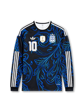 2026年アルゼンチン代表ワールドカップアウェイロングスリーブユニフォーム正面、ブラックベース、ブルー流線グラフィック、胸元代表エンブレム、3つ星、ゴールド系チャンピオンバッジ、前面背番号10、白ショルダーストライプ