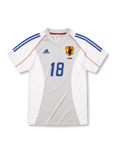 日本代表2002-04アウェイユニフォーム前面・ホワイト×グレーのパネル構成にブルーの2本ラインとレッドのパイピング、旧JFA八咫烏エンブレムとJAPAN表記、中央にブルーの背番号18