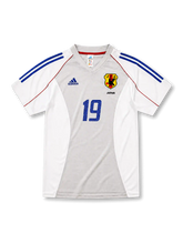 日本代表2002-04アウェイユニフォーム前面・ホワイト×グレーのパネル構成にブルーの2本ラインとレッドのパイピング、旧JFA八咫烏エンブレムとJAPAN表記、中央にブルーの背番号19