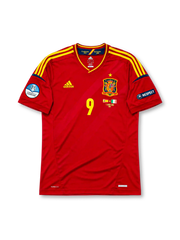 レッドベースに肩のイエロー3本ラインとネイビー袖口ラインを配し、胸にadidasロゴ、星付きスペインサッカー連盟エンブレム、イエローの9番、決勝戦カード(スペインvsイタリア 2012年7月1日キエフ)表記、左袖にUEFAユーロ2012優勝エンブレム、右袖にRESPECTパッチ、裾にCLIMACOOL表記を備えたスペイン代表2012ユーロ決勝記念ホームジャージ正面