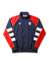 アーセナル adidas Originals 復刻トラックジャケット ネイビー/レッド — レッド肩パネルとホワイト・イエロー袖ストライプ、ヴィンテージ盾形エンブレムを配した復刻ライフスタイルライン