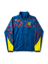 FCバルセロナ Nike グラフィックウィンドブレーカー ロイヤルブルー 前面 — レッド抽象グラフィックパターンとイエロー脇パネル、盾形エンブレム刺繍を配した公式トレーニングライン