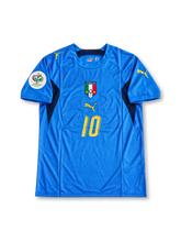 イタリア代表 2006年ドイツワールドカップ ホームユニフォーム フランチェスコ・トッティ10番 PUMA製アズーロブルーのボディにネイビーのショルダーとサイドパネル、ゴールドのプーマロゴと背番号10、三つ星入りイタリア代表エンブレム、2006 FIFAワールドカップ大会袖パッチを配したレトロサッカージャージ