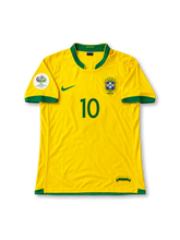 ブラジル代表 2006年ワールドカップ ホームユニフォーム ロナウジーニョ10番。Nike製のカナリアイエローのボディにグリーンのVネックと袖口を組み合わせ、胸元にグリーンのNikeロゴ、5つ星付きCBFエンブレム、グリーンの10番を配したレトロサッカージャージ。ドイツワールドカップ2006の袖章を備え、背面にはRONALDINHOのネームとグリーンの10番をあしらったデザイン。