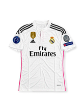 レアル・マドリード 2014/15シーズン ホームユニフォーム クリスティアーノ・ロナウド7番。adidas製ホワイトのボディに繊細な幾何学模様、ブラックの肩のスリーストライプ、ピンクのサイドラインと背面上部のアクセントを組み合わせたレトロサッカージャージ。ボタン付きの丸襟を採用し、胸元にはadidasロゴ、レアル・マドリードのクラブエンブレム、Fly Emiratesスポンサーロゴを配置。背面にはRONALDOのネームとダークカラーの7番を配したデザイン。