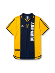 イエローの肩袖にネイビーの中央パネル、左胸のadidasロゴ、中央のAJAXクラブエンブレム、縦書きの白いABN・AMROスポンサーロゴを備えたアヤックス2000/01アウェイジャージ正面