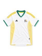 南アフリカ代表 2002 アウェイユニフォーム。ホワイトのボディにグリーンのVネックと袖口、イエローのadidasスリーストライプ、南アフリカサッカー協会のエンブレム、両脇のイエローメッシュを配したデザイン。