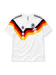 ホワイトベースに黒赤黄のシェブロン柄、肩の黒スリーストライプ、左胸のadidasロゴとITALIA'90の文字、右胸のDFBイーグルエンブレムを備えたドイツ代表1990ホームジャージ正面
