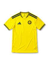 鮮やかなイエローベースに紺のアラベスク柄の襟と袖口、左胸のadidasロゴ、NASSR RIYADH 1955と記された円形クラブエンブレムを備えたアル・ナスル2026-27ホームジャージ正面