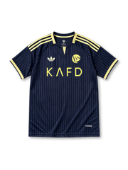 紺の細ピンストライプに黄色い肩ラインと襟、白いadidasトレフォイルロゴ、黄色いクラブエンブレム、KAFDのスポンサーロゴを備えたアル・ナスルFC2026-27アウェイシャツ正面