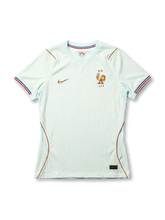 フランス代表 2026 アウェイジャージ Authentic 正面 — ミントホワイトジャカード、ゴールド雄鶏エンブレム、コパーパイピング、トリコロール袖口