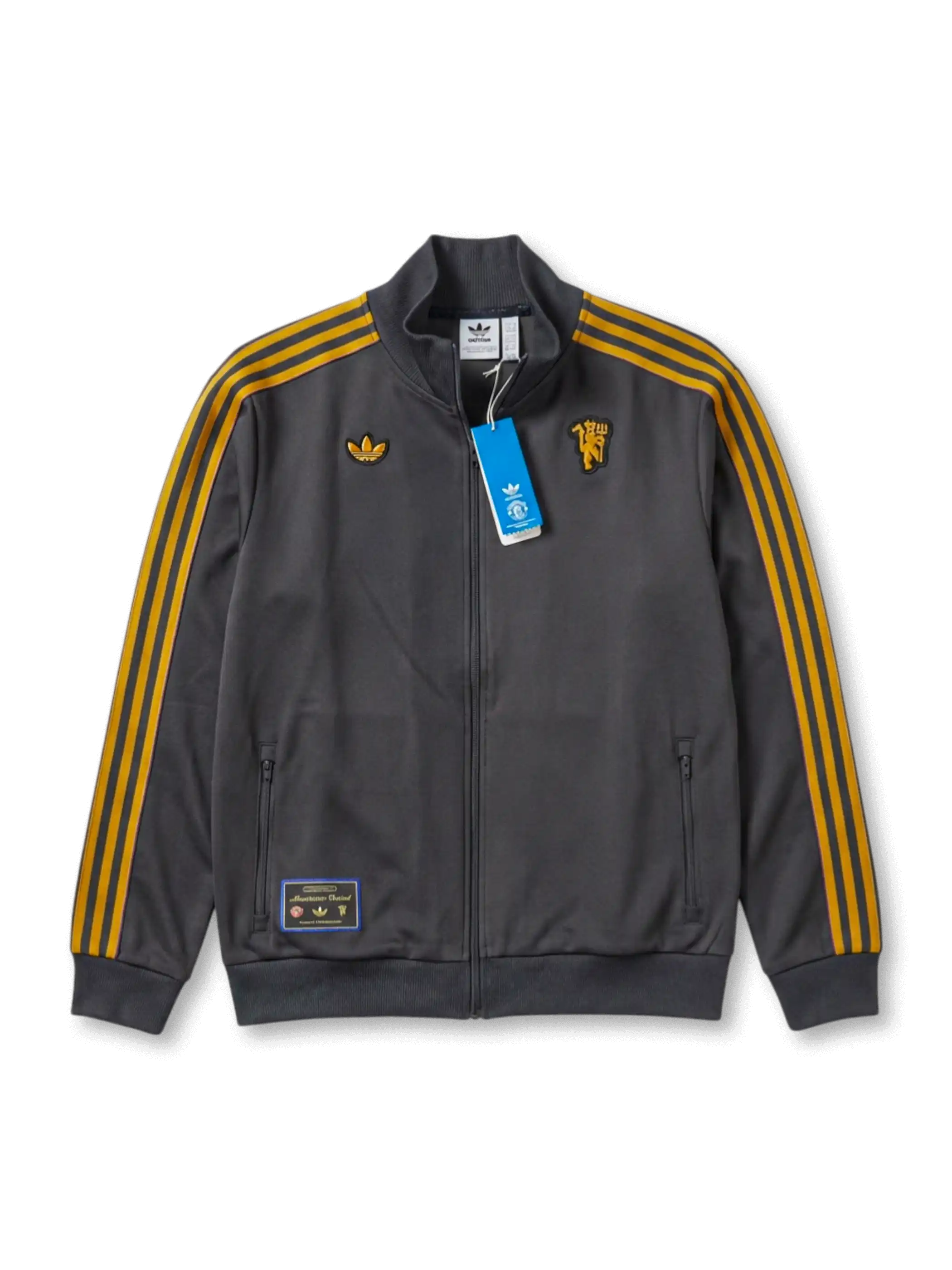 マンチェスター・ユナイテッド adidas Originals 復刻トラックジャケット チャコール — ゴールドストライプとヴィンテージエンブレムを配したライフスタイルライン