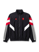 マンチェスター・ユナイテッド adidas Originals 復刻トラックジャケット ブラック — 赤白二重シェブロンパネルとレッドデビル立体刺繍を配した復刻ライフスタイルライン