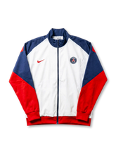 パリ・サンジェルマン Nike トラックジャケット ホワイト/ネイビー/レッド — 三色切替パネルとPSG現行円形エンブレム刺繍を配した公式トレーニングライン