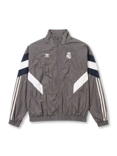 レアル・マドリード adidas Originals 復刻トラックジャケット グレー — ネイビー×ホワイト二重シェブロンパネルとクラウンエンブレム刺繍を配した復刻ライフスタイルライン