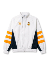 レアル・マドリード adidas Originals 復刻トラックジャケット ホワイト/オレンジ — オレンジ3ストライプとネイビー脇パネル、ヴィンテージクラウンエンブレムを配した復刻ライフスタイルライン