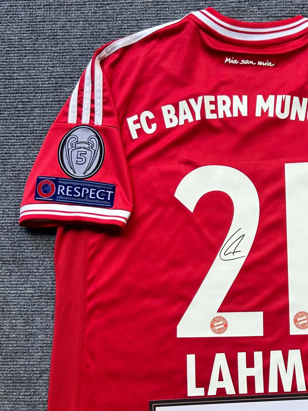 製品画像：「2013-14シーズン バイエルン・ミュンヘン ラームサイン入り 21番クラシックホームユニフォーム 正面展示。ラーム直筆サイン、クラシックデザイン、ヨーロッパチャンピオンズリーグ ワッペン、高密度刺繍、吸汗・透湿・速乾性に優れた快適素材でファン必携。」

詳細画像：「バイエルンのエンブレム刺繍、ラームのサイン、ユニフォーム背面のディテールの拡大。ラーム記念品としてファンやコレクターに人気。」