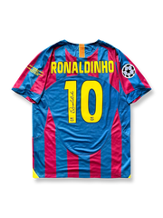 製品画像：「2005-06シーズン バルセロナ ロナウジーニョサイン入り 10番 ホームヴィンテージユニフォーム 正面展示。ロナウジーニョ直筆サイン、クラシックデザイン、ヨーロッパチャンピオンズリーグ ワッペン、高密度刺繍でファン必携。」

詳細画像：「バルサのエンブレム刺繍、ロナウジーニョのサイン、ユニフォーム背面のディテールの拡大。ロナウジーニョ記念品としてファンやコレクターに人気。」