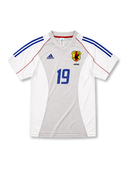 日本代表2002-04アウェイユニフォーム前面・ホワイト×グレーのパネル構成にブルーの2本ラインとレッドのパイピング、旧JFA八咫烏エンブレムとJAPAN表記、中央にブルーの背番号19
