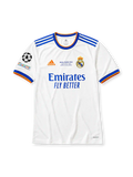 ホワイトベースにブルー×オレンジの襟と袖口ラインを配し、右袖にUEFAチャンピオンズリーグ13度優勝エンブレムとUEFAファウンデーションパッチを備え、背面にブルーのBENZEMAネームと9番、その下にレアル・マドリードのクラブエンブレムをあしらったレアル・マドリード2021-22ホームジャージ背面