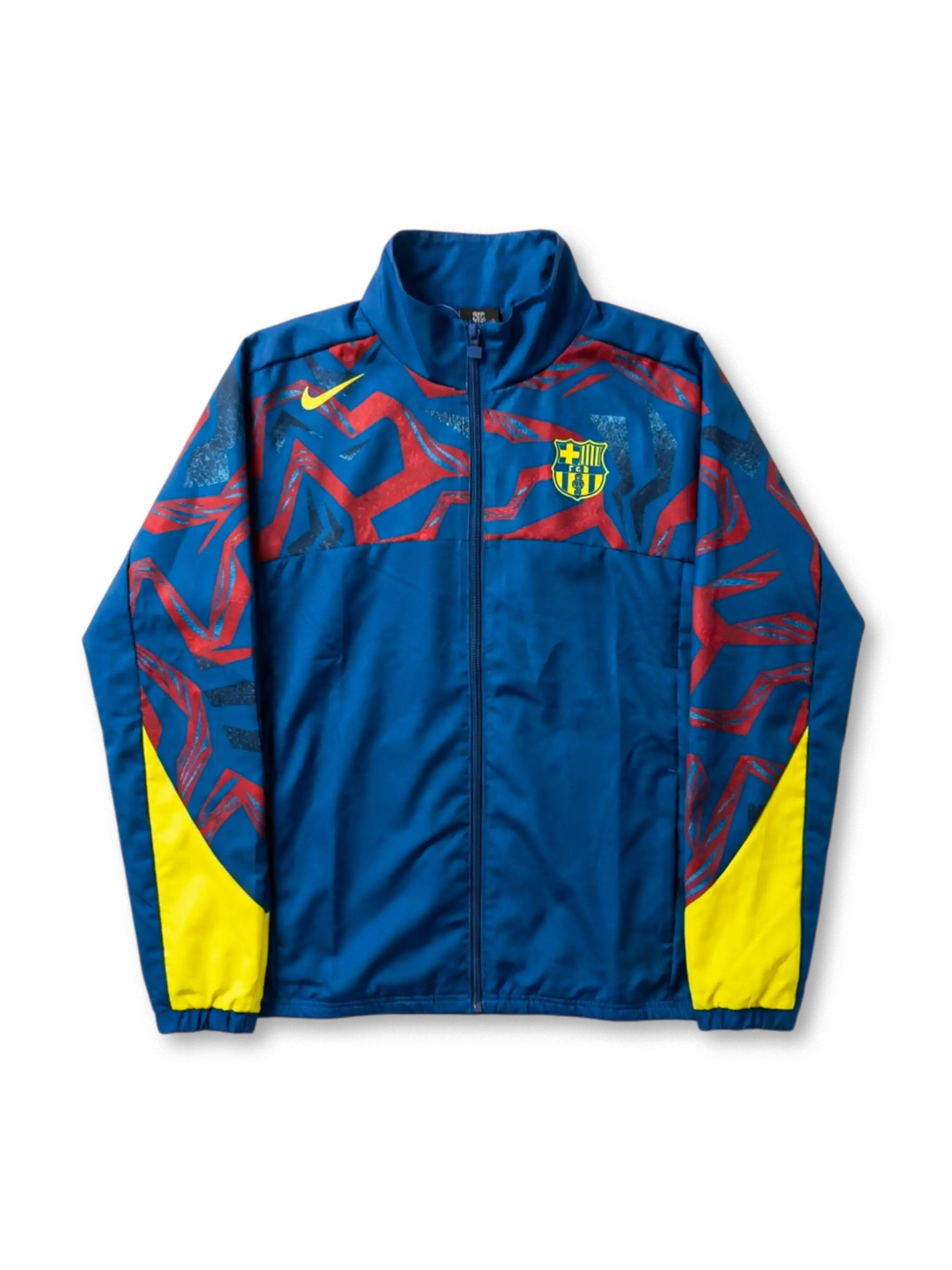 FCバルセロナ Nike グラフィックウィンドブレーカー ロイヤルブルー 前面 — レッド抽象グラフィックパターンとイエロー脇パネル、盾形エンブレム刺繍を配した公式トレーニングライン
