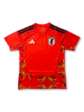 日本代表 adidas ゴールキーパージャージ 2026-27 レッドフレーム 前面 — 炎・植物文様グラフィックパネルとJFA八咫烏エンブレムを配した現行GKモデル